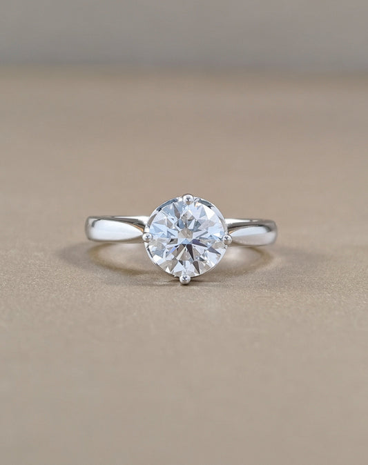 A classic solitaire engagement ring featuring a round brilliant-cut clear gemstone in a four-prong setting on a polished white gold
