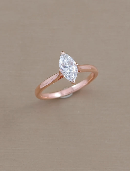 Angled view of marquise lab grown diamond solitaire engagement ring with polished rose gold band