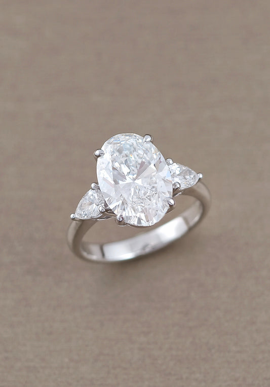 Oval diamond engagement ring with pear-cut side stones