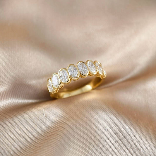 Side view of an Oval Bezel Lab Grown Diamond Half Eternity Ring handcrafted in 18K Yellow Gold