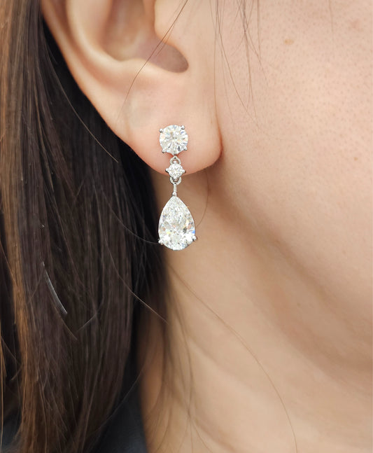 Model wearing Solene Round & Pear Three Stone Lab Grown Diamond Drop Earrings with IGI Certified lab grown diamonds by Sphere Diamond Bangkok