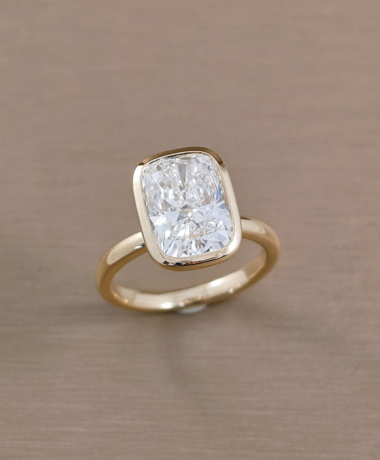 Angled view of cushion bezel set lab grown diamond ring with minimalist design