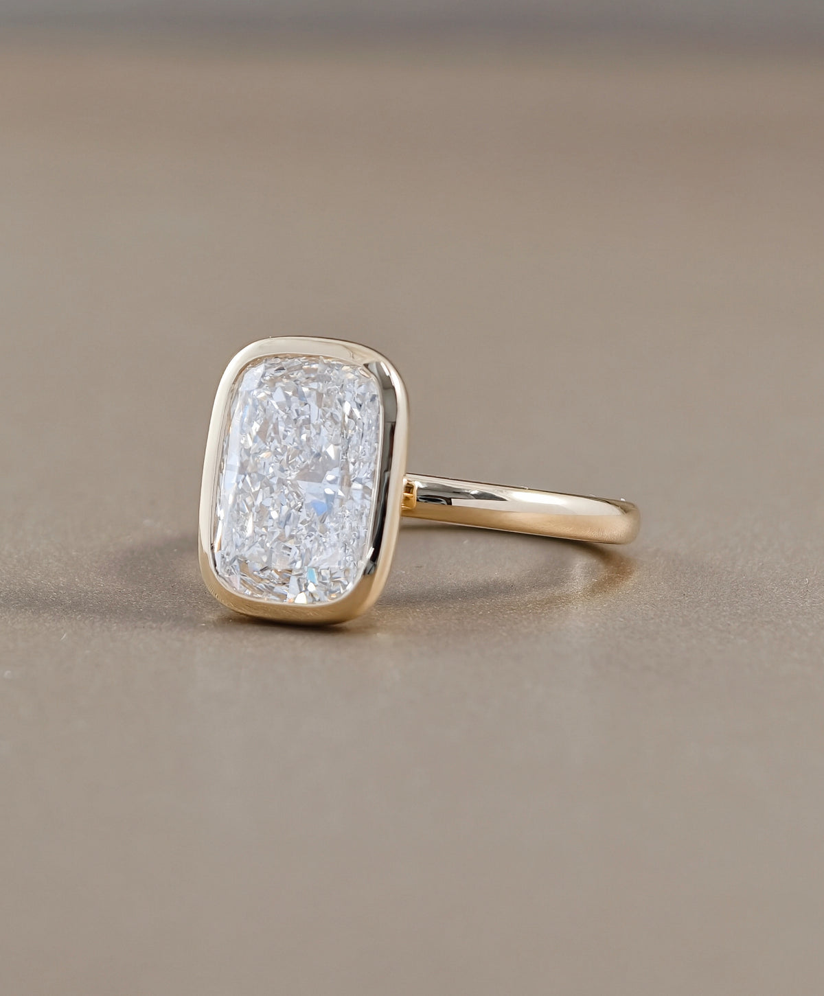 Side view of cushion cut lab grown diamond engagement ring with modern bezel setting