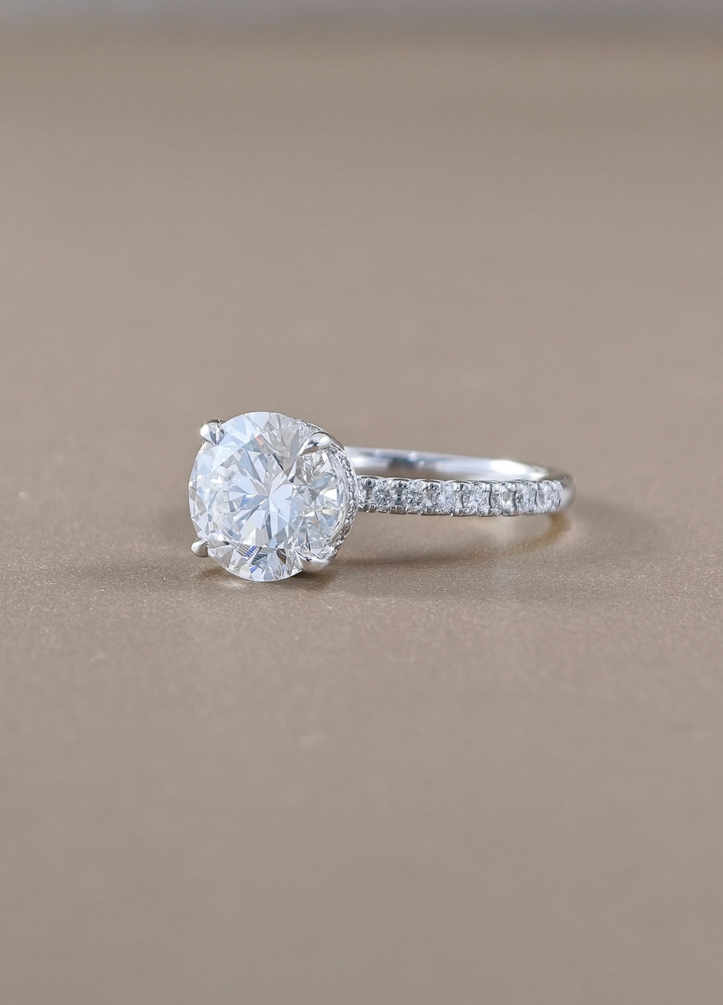 A round-cut solitaire engagement ring with a pavé band