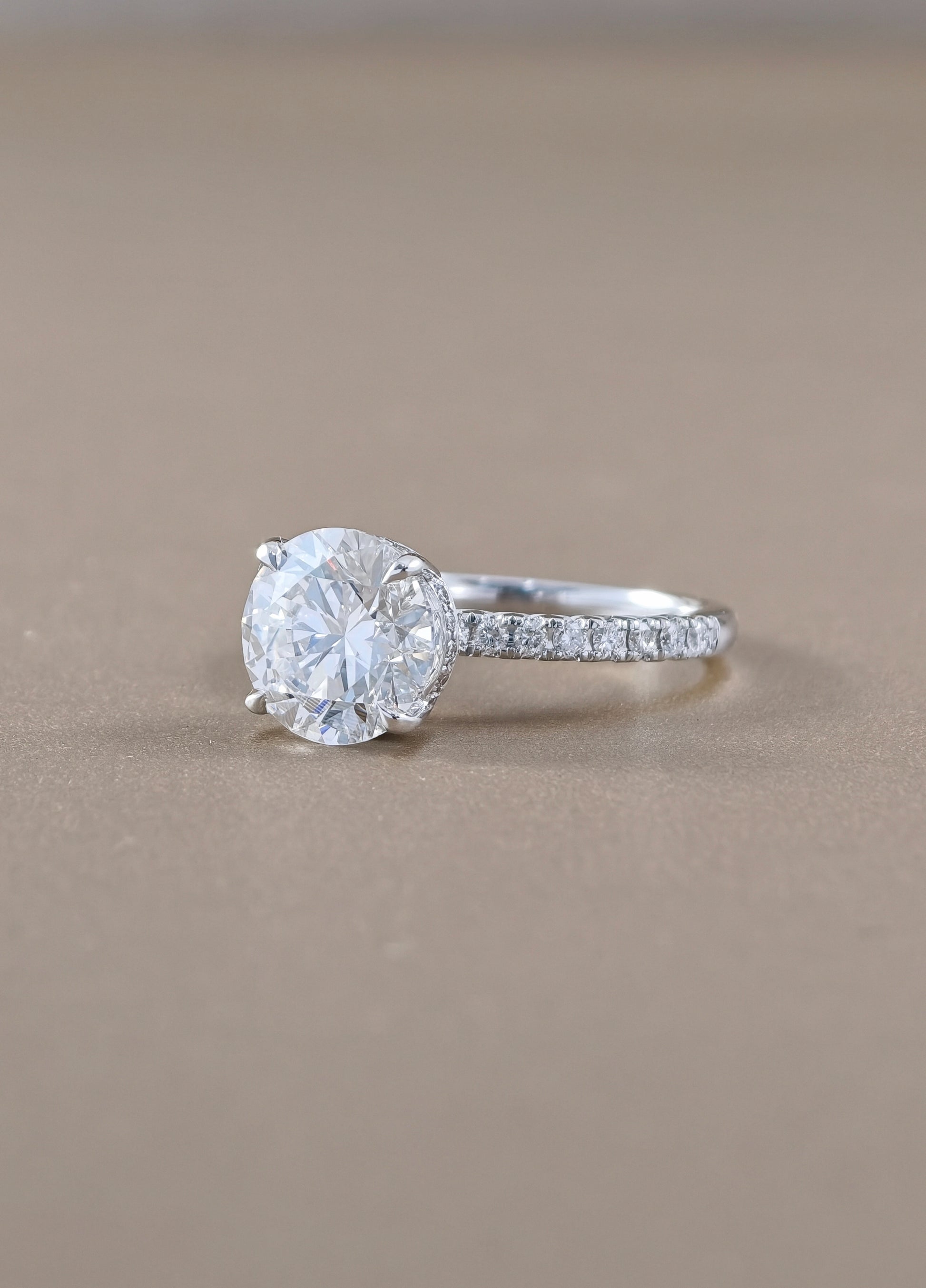 A round-cut solitaire engagement ring with a pavé band