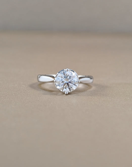 A classic solitaire engagement ring featuring a round brilliant-cut clear gemstone in a four-prong setting on a polished white gold