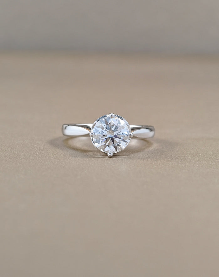 A classic solitaire engagement ring featuring a round brilliant-cut clear gemstone in a four-prong setting on a polished white gold