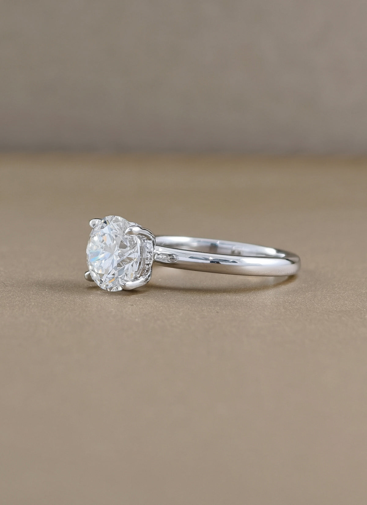 A classic solitaire engagement ring featuring a round brilliant-cut  in a four-prong setting , white gold 