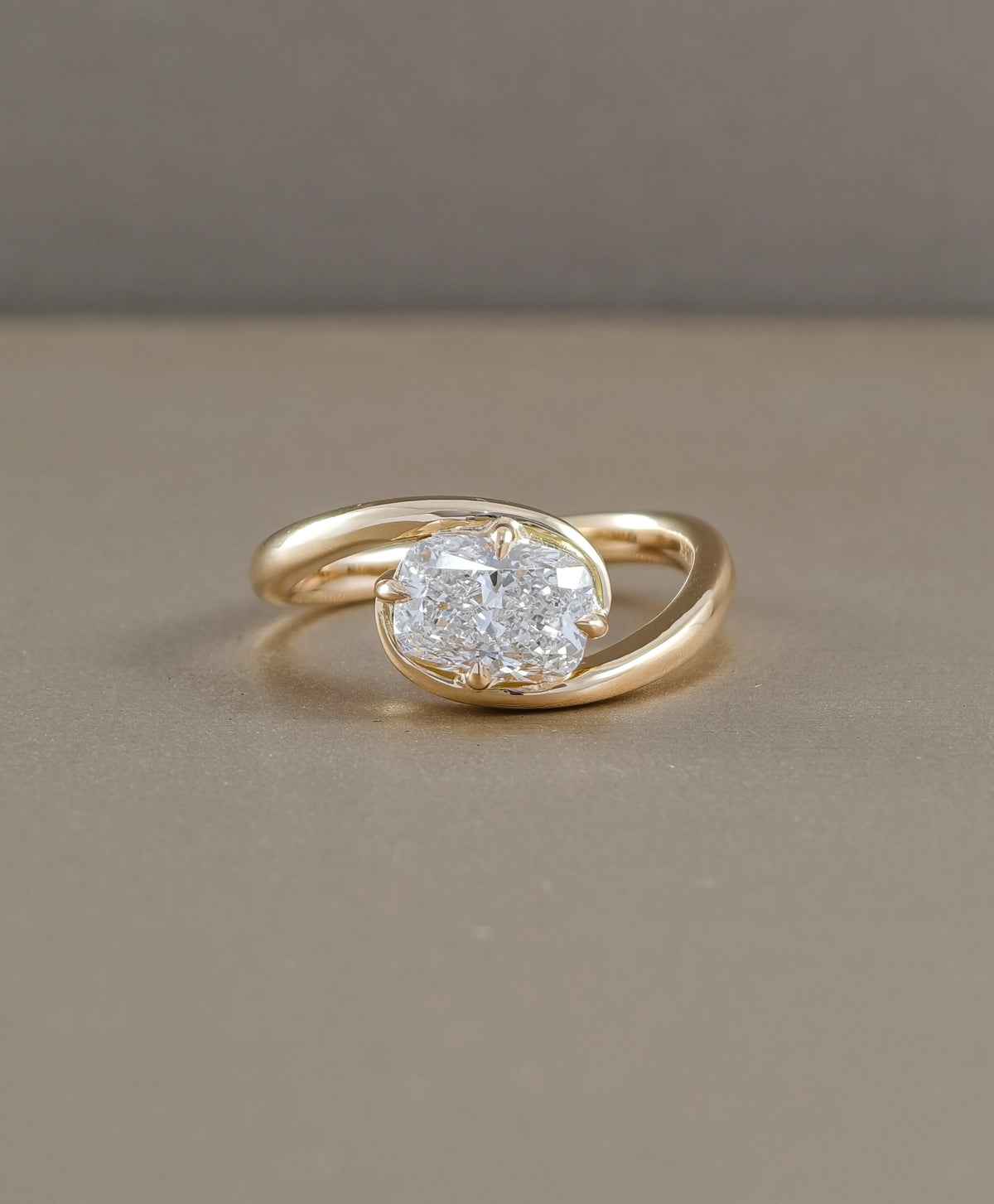 Horizontal cushion solitaire lab grown diamond ring in yellow gold with flowing twist band