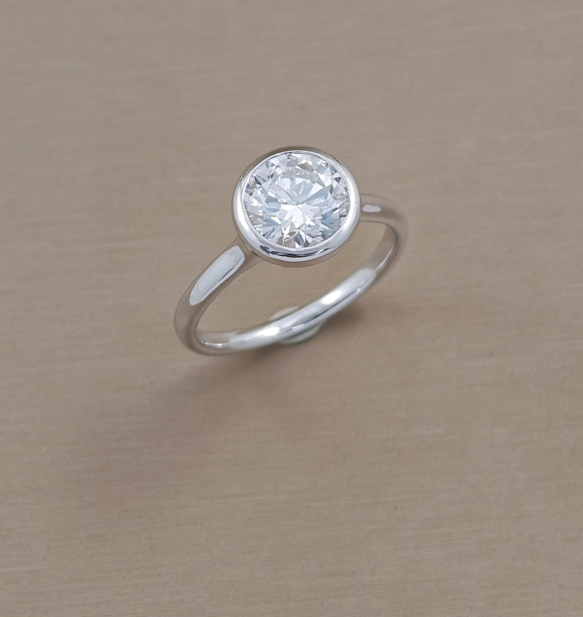 Round bezel set lab grown diamond engagement ring with polished white metal band, Sphere Diamond Bangkok