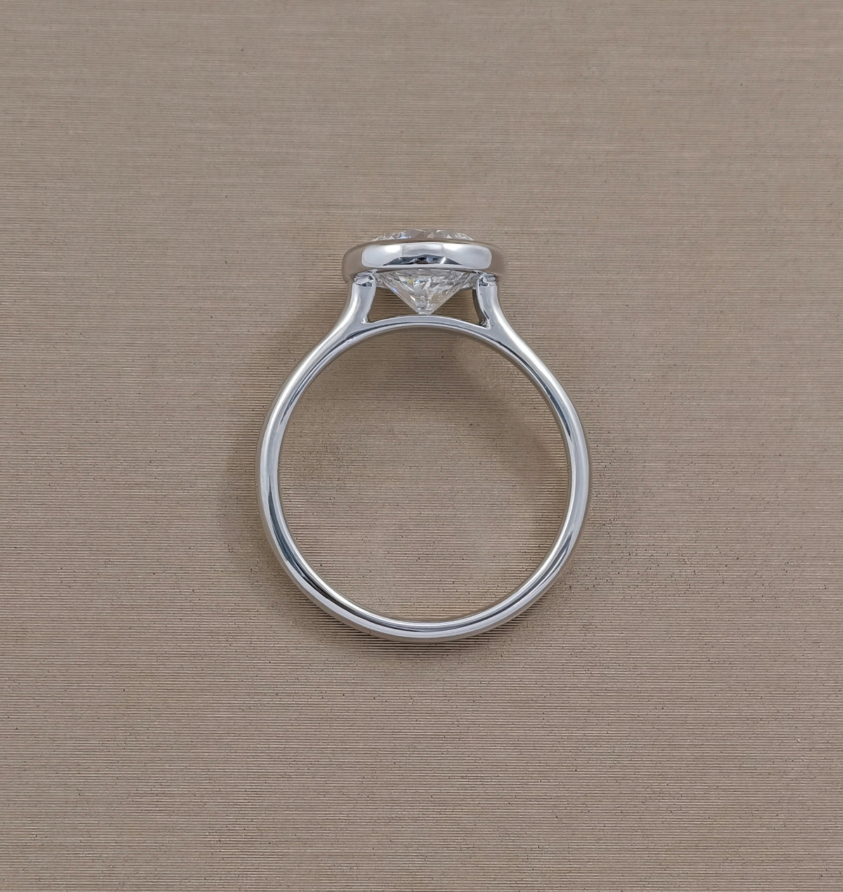 Round bezel set lab grown diamond engagement ring with polished white metal band, Sphere Diamond Bangkok