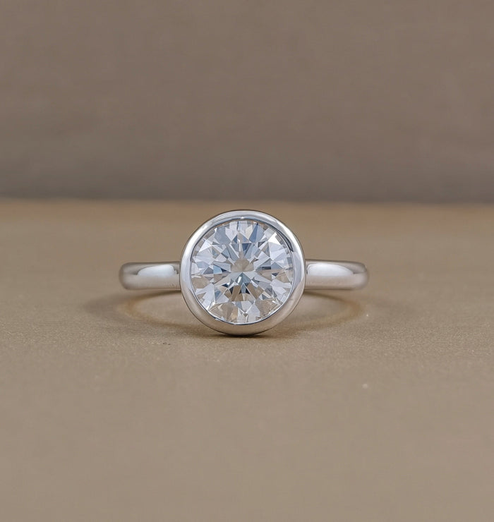 Round bezel set lab grown diamond engagement ring with polished white metal band, Sphere Diamond Bangkok