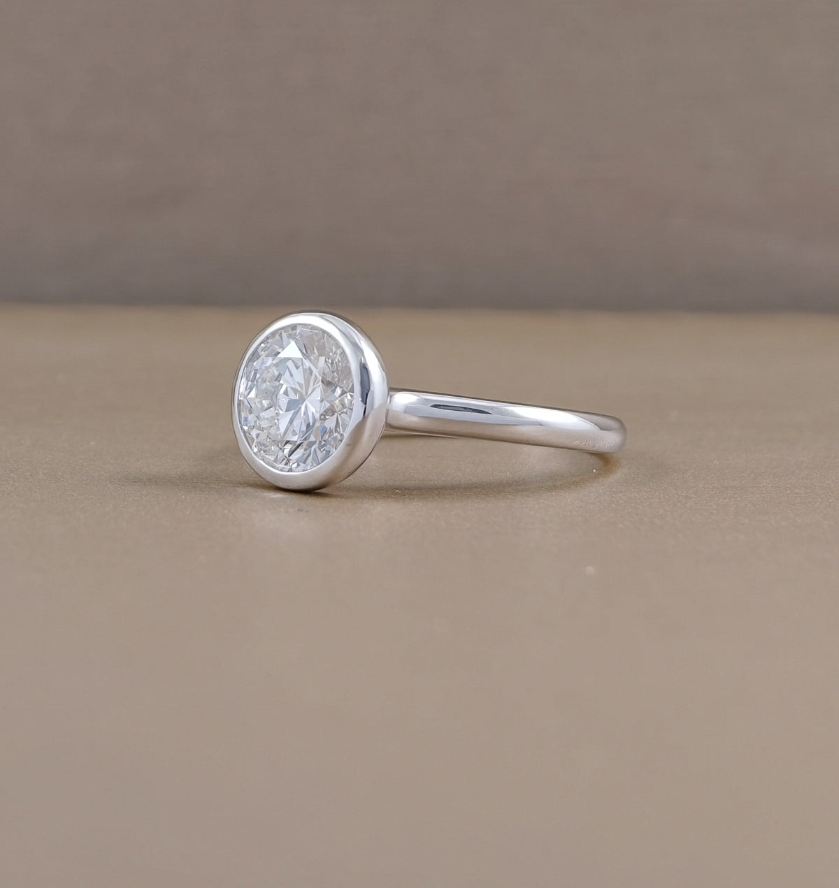 Round bezel set lab grown diamond engagement ring with polished white metal band, Sphere Diamond Bangkok