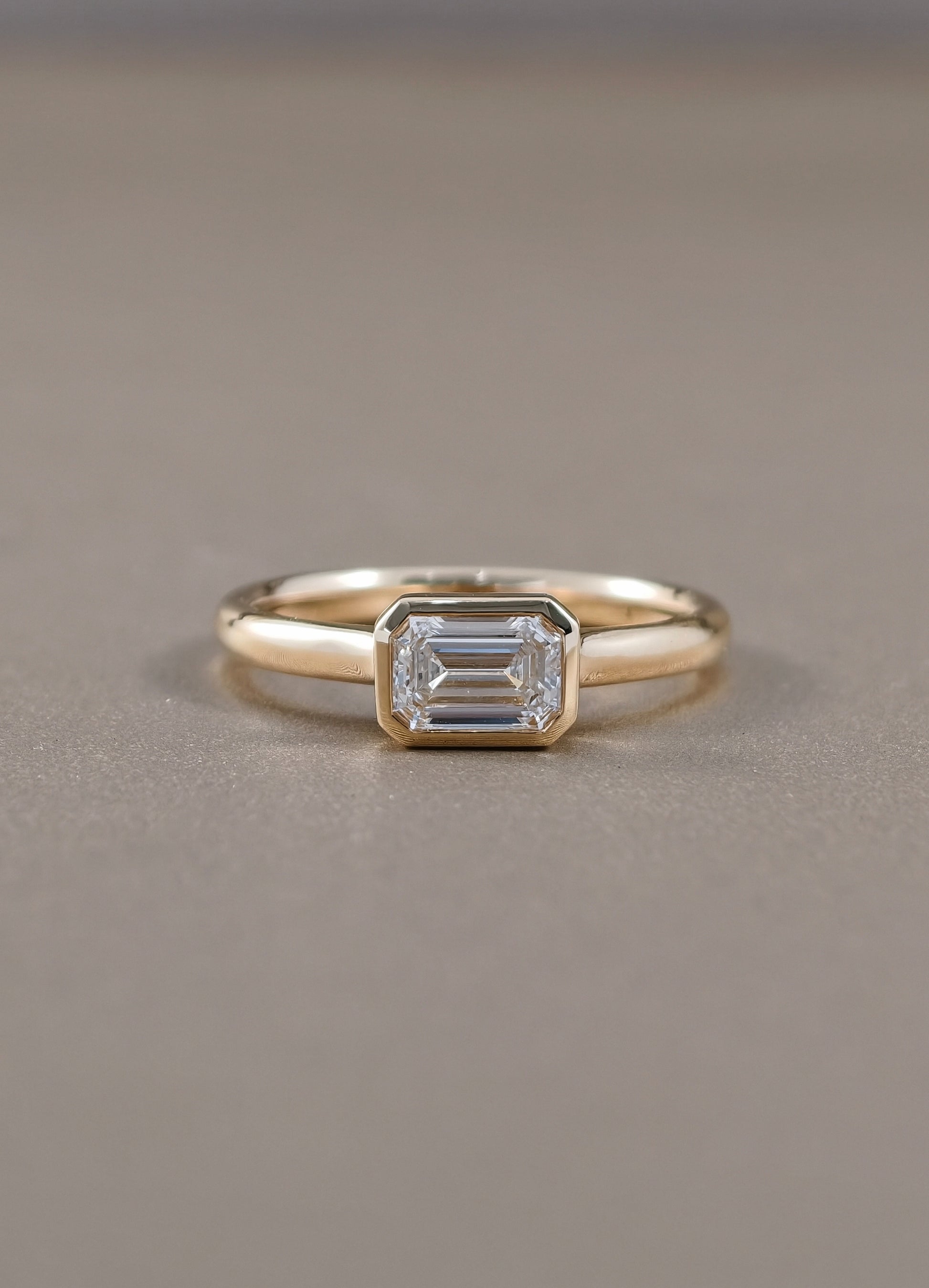 East-West Emerald Cut Lab Grown Diamond Bezel Engagement Ring in Yellow Gold by Sphere Diamond Bangkok