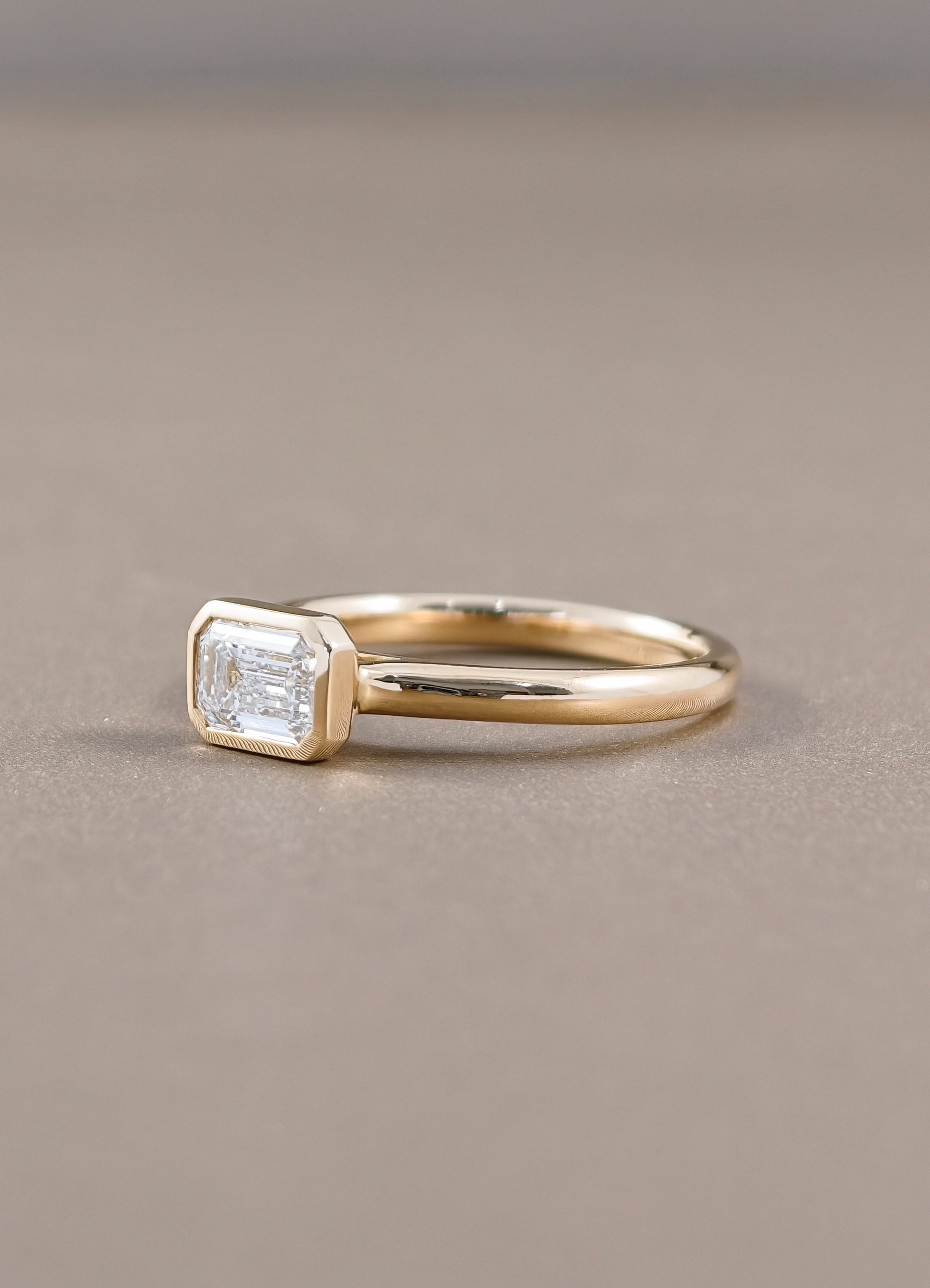 East-West Emerald Cut Lab Grown Diamond Bezel Engagement Ring in Yellow Gold by Sphere Diamond Bangkok