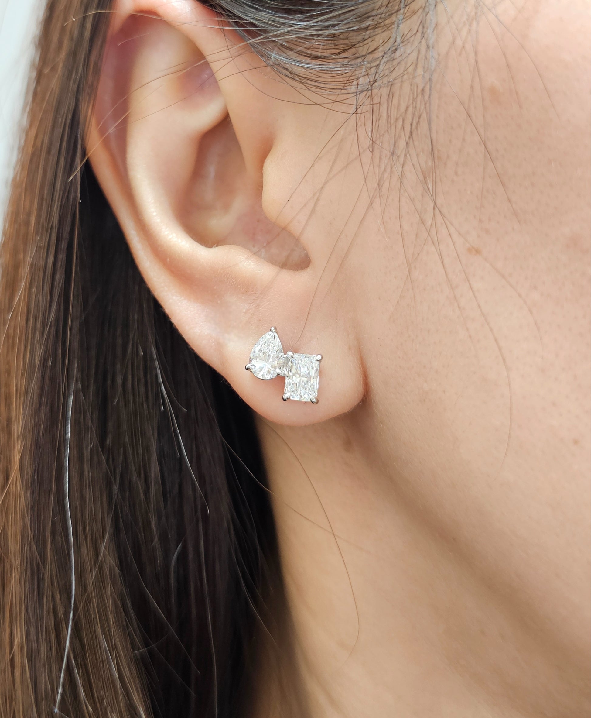 Model wearing Luna Pear and Emerald Toi et Moi lab grown diamond stud earrings by Sphere Diamond Bangkok